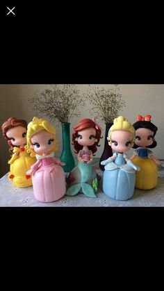 some disney princess figurines sitting on top of a table