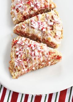 three slices of peppermint scones on a white plate with candy canes