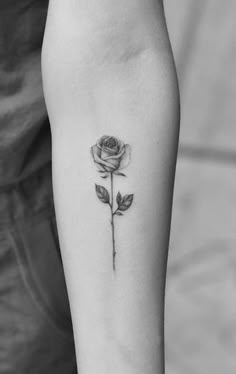 a single rose tattoo on the left inner arm