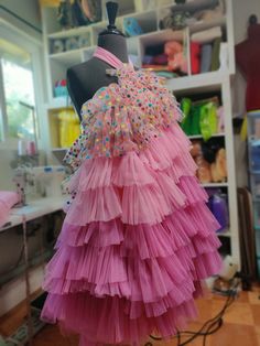 a dress on a mannequin in a room with shelves and other items behind it