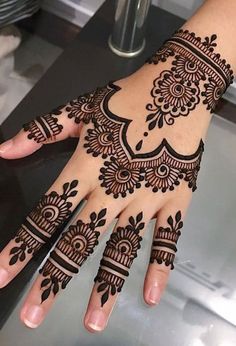 a woman's hand with henna tattoos on it