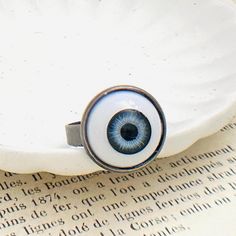 Looking to put a little fright in someone's day? My ghoulish eyeball ring can deliver a wallop full of fear and is certain to turn heads. It makes a scary accessory to wear during the Halloween holiday or any time of year. It features a realistic eyeball adhered onto an adjustable antique silver plated ring. The eyeball is about 16mm in diameter. Fits most sizes. ♥ See more Halloween jewelry here: https://www.etsy.com/shop/iceblues/items?ref=listing-shop-header-item-count§ion_id=10461899 GIFTS Each item is individually wrapped in a branded jewelry gift box. We do not include price receipts in the package. We are happy to ship directly to the recipient. EXPEDITED SHIPPING At checkout, you have the option to choose faster shipping in the drop-down menu. Ship times do NOT include production t Realistic Eyeball, Eyeball Ring, Creepy Eyeball, Goth Ring, Halloween Ring, Halloween Eyeballs, Evil Eye Ring, Eye Ring, Ring Blue