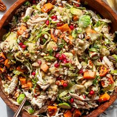 a wooden bowl filled with salad and dressing