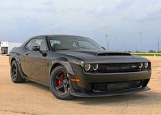 a black sports car parked in an empty lot