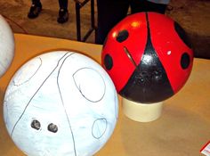 three painted ladybugs sitting on top of a wooden table next to each other