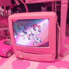 an old tv sitting on top of a pink table