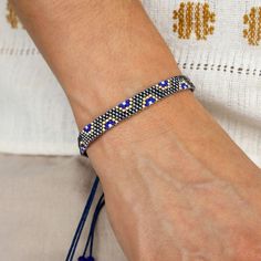 a woman wearing a blue beaded bracelet on her wrist and holding onto a string