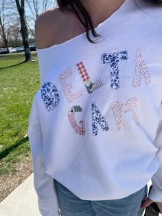 a woman wearing a white shirt that says eat a game on it and has her hands in her pockets