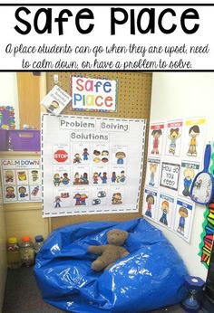 a blue bag sitting on top of a floor in front of a bulletin board with words and pictures