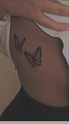 a woman's stomach with two butterflies on her side and the bottom part of her belly