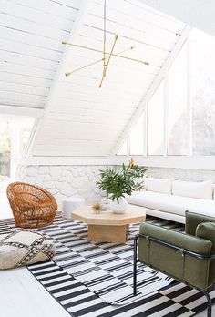 a living room with white walls and black and white striped rugs on the floor