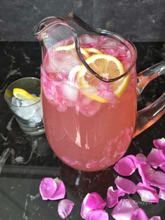 a pitcher filled with pink liquid and lemon wedges