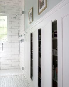 a bathroom with white walls and tile flooring next to a walk - in shower