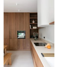 a kitchen with wooden cabinets and white counter tops, along with a bench in the center