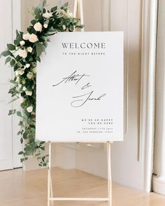 a welcome sign with white flowers and greenery