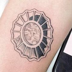 a woman's arm with a tattoo on it that has an image in the center