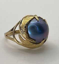 "Vintage 14K solid yellow gold purple Tahitian Mabe pearl solitaire ring! This ring is approximately a size 6.75. It measures approximately 16mm diameter at the head and the dome shape stands approximately 9mm out from the finger. The luxurious purple Mabe pearl is firmly set and intact with beautiful blueish purple color and smooth pearly finish. There are no cracks or chips and the luster is intact with no chalkiness or scuffing. The inside of the band is stamped for \"14K\" gold and a maker's Elegant Iridescent Cabochon Ring, Elegant Iridescent Opal Ring With Cabochon, Elegant Iridescent Cabochon Opal Ring, Yellow Gold Tahitian Pearl Ring, Gold Rings With Tahitian Pearl For Gift, Elegant Iridescent Opal Ring For Anniversary, Formal Yellow Gold Tahitian Pearl Ring, Elegant Iridescent Rings For Formal Occasions, Elegant Iridescent Moonstone Ring