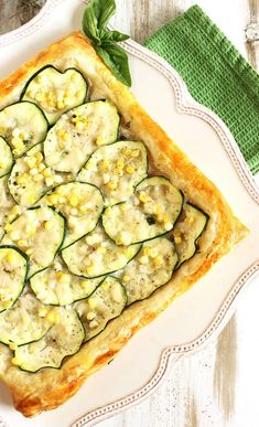 a white plate topped with a cucumber tart next to a green napkin