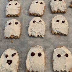 cookies decorated with icing and ghost faces are on a baking sheet, ready to be baked