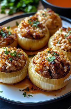 several stuffed mushrooms on a plate with sauce and parsley