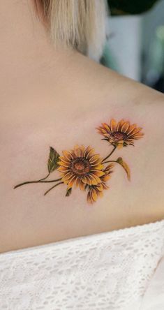 a sunflower tattoo on the back of a woman's upper arm and shoulder