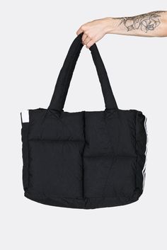 a hand holding a black tote bag