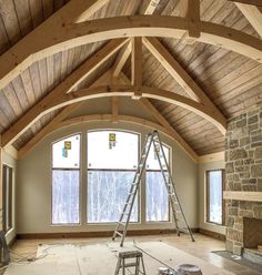 a large room with wooden beams and windows in the ceiling, being built into the wall