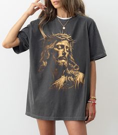 This Jesus Vintage Shirt features a retro-inspired graphic of Jesus Christ, making it a unique and meaningful piece of religious apparel. It's designed with a timeless vintage aesthetic, perfect for anyone looking to express their faith with style. This t-shirt makes a thoughtful Christmas gift for him, combining comfort and a message of faith. Made from soft, high-quality fabric, it's suitable for casual wear or special occasions. Ideal for believers who appreciate classic, spiritual designs. 🎀Welcome to the Modtrendy Clothing👕🎁 BLACK TEXT is used for Yellow, Heather Peach, White, Athletic Heather, Mint, Pink, Baby Blue Shirts. Other colored shirts have white text. F I T ∙ & ∙ S I Z I N G : ✨Women's sizes are narrower than the waist. ✨Sleeves are rolled up in some product pictures. The Baby Blue Shirt, Blue Shirts, Christmas Gift For Him, Thoughtful Christmas Gifts, Clothing Black, Christmas Gifts For Him, Jesus Shirts, Product Pictures, Pink Baby