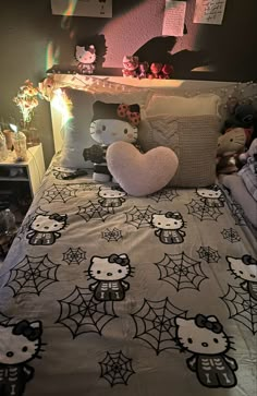 a hello kitty bed spread and pillows in a bedroom with lights on the headboard