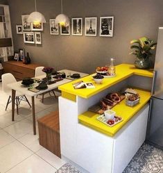 a kitchen with yellow counters and pictures on the wall