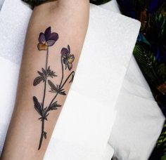 a woman's arm with a flower tattoo on it