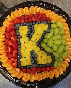 a platter with fruit arranged in the letter k