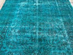 a blue rug with an intricate design on the top and bottom, in shades of teal