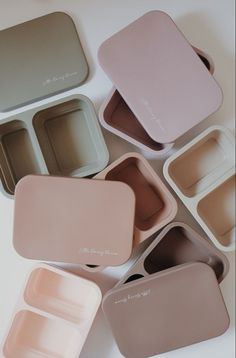 six square trays with different colored lids on top of each other, one empty and one closed