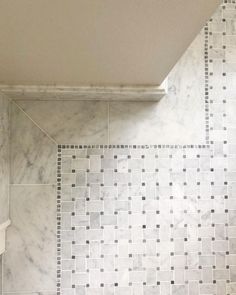 a bathroom with white and black tile on the walls