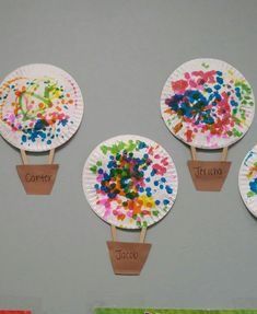 four paper plates with different colored sprinkles on them are hanging from the wall