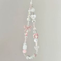 a pink and white beaded necklace with charms