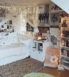 a bedroom decorated in white with lights strung from the ceiling and pictures on the walls