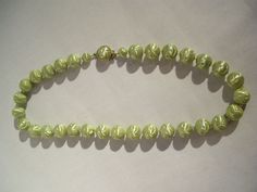 "This pretty mint green vintage necklace dates from the 50s. It is made of green lucite beads 5/8 \"(1.7 cm) in diameter in which there are festoons and small rounds. Each of these beads are spaced apart by tiny beads of clear, colorless glass. It is 23 \"(58.5 cm) long. The gold metal clasp is decorated with a half green pearl. This jewel is in excellent condition and is kept in a smoke and pet free environment." Retro Green Beaded Necklace For Gift, Formal Green Beaded Necklace, Retro Green Beaded Necklaces, Formal Green Single Strand Beaded Necklace, Vintage Green Beaded Necklaces With Round Beads, Vintage Green Beaded Necklace With Round Beads, Vintage Green Round Bead Necklaces, Vintage Green Necklaces With Round Beads, Vintage Green Single Strand Necklace