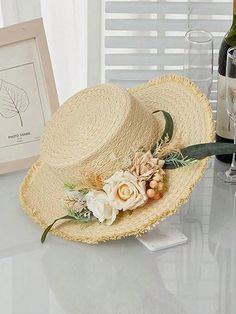 a hat sitting on top of a table next to wine glasses and a framed photograph