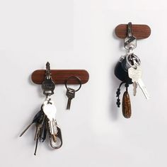 two wooden key holders with keys hanging from the hooks on each side, one holding several different types of keys