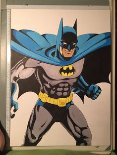 a drawing of the batman is being displayed in front of a person's hand