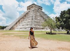 a woman standing in front of an ancient pyramid