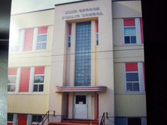 an old school building with stairs leading up to it