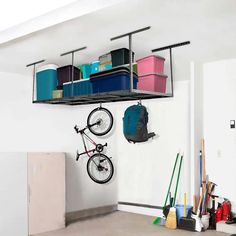 there is a bike hanging on the wall next to some bins and other items