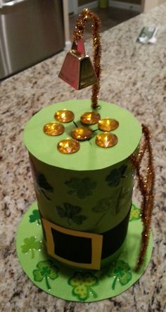 this is a cake made to look like a green hat with gold cups on it