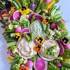 an arrangement of flowers and vegetables arranged in the shape of a circle