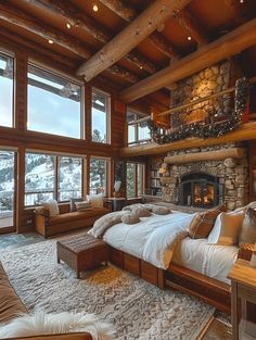 a large bedroom with stone fireplace and wooden walls, along with windows that look out onto the snow covered mountains