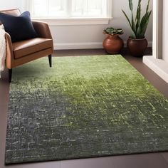 a living room area with a chair, rug and potted plant