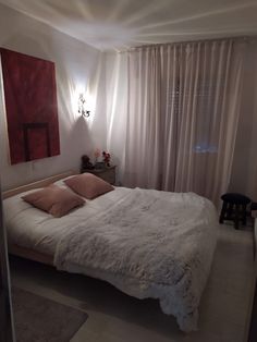 a bedroom with a large bed and white walls